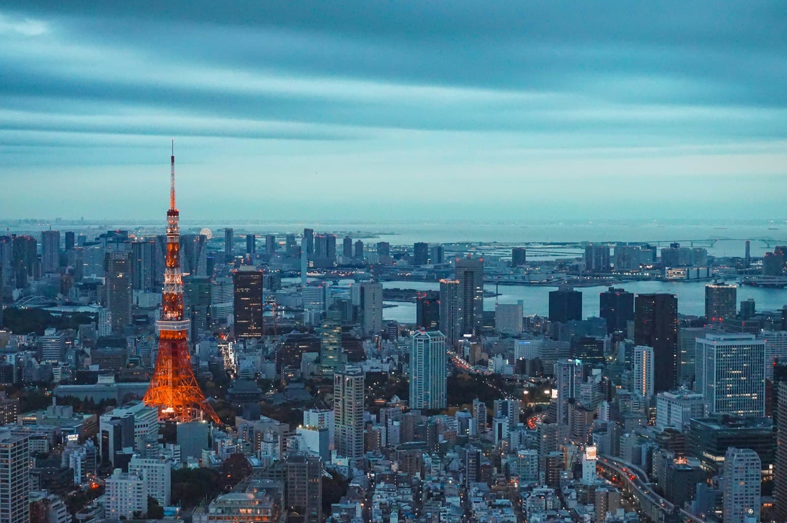 Tokyo Tower lit up against the city skyline at dusk